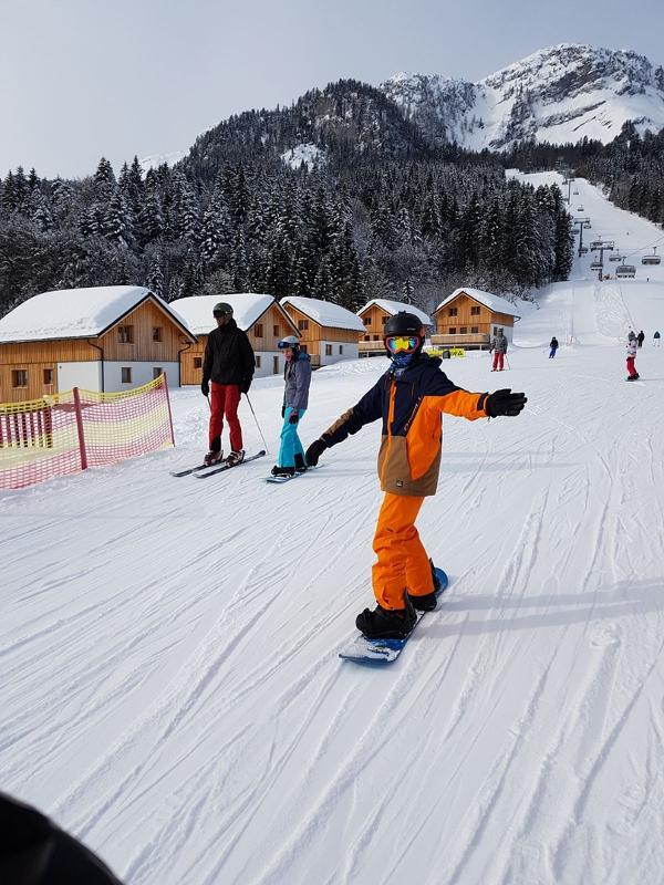 Teilnehmer eines Sportlagers fahren Snowboard