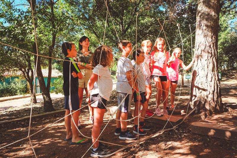 Kinder der Englisch-Ferien bauen ein Spinnennetz