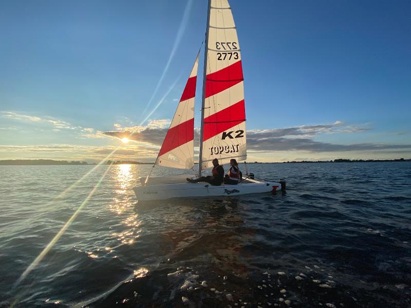 Zwei Jungs eines Feriencamps am Wasser segeln