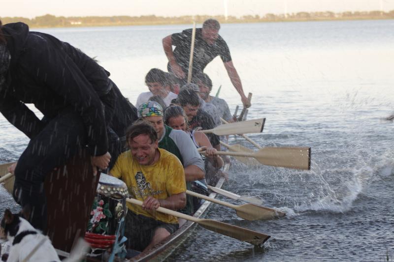 Kinder eines Feriencamps am Wasser rudern