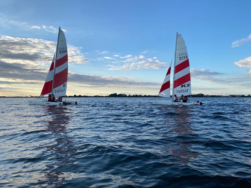Zwei Segelboote fahren bei einer Ferienfreizeit übers Wasser