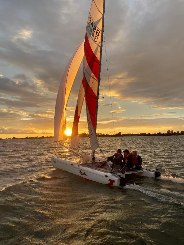 Kinder eines Feriencamps am Wasser fahren ins Licht