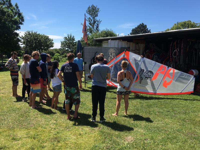Der Trainer erklärt den Jugendlichen im Windsurfcamp spezielle Techniken.