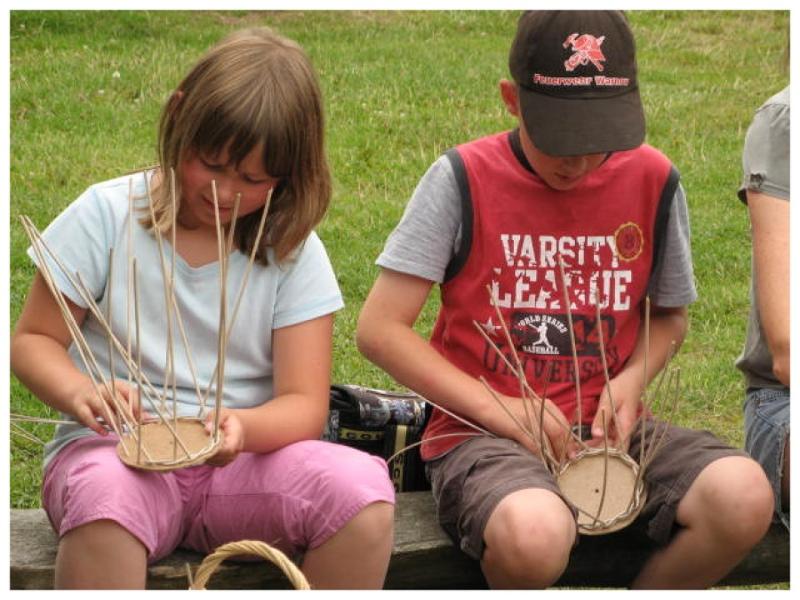 Teilnehmer des Kinder und Jugendcamps flechten