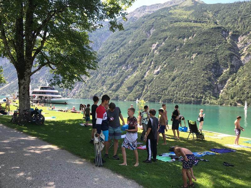 Kinder stehen auf einer Badewiese am See im Outdoorcamp