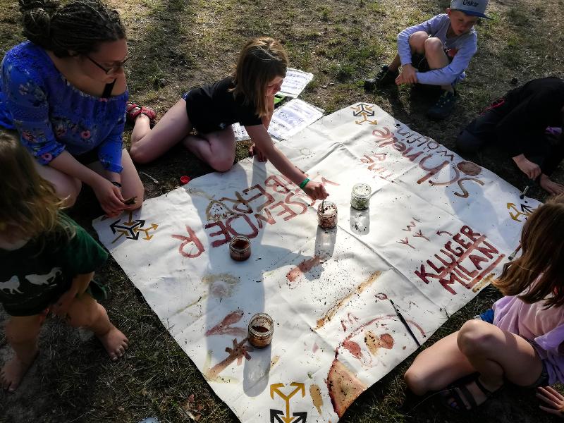 Teilnehmer eines Zeltlagers malen Plakate