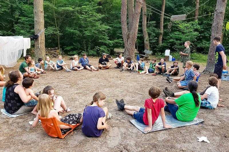 Teilnehmer eines Zeltlagers sitzen zusammen im Kreis