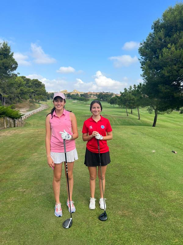 Zwei Freundinnen stehen mit dem Schläger in der Hand während der Sprachreise Spanien auf einem Golfplatz
