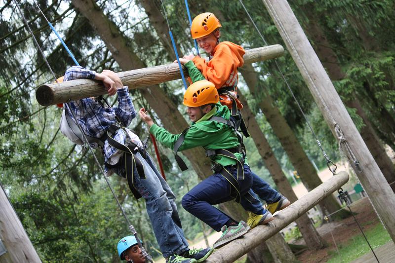 Mehrere Kinder haben im Sportcamp zusammen Spaß beim Klettern