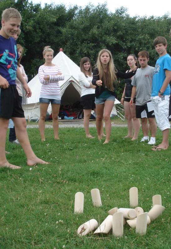 Teilnehmer eines Feriencamp Hannover spielen gemeinsam ein Spiel auf einer Wiese