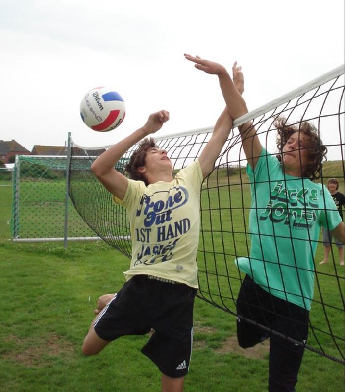 Zwei Teilnehmer spielen bei ihrem Feriencamp Hannover einen Ball übers Netz