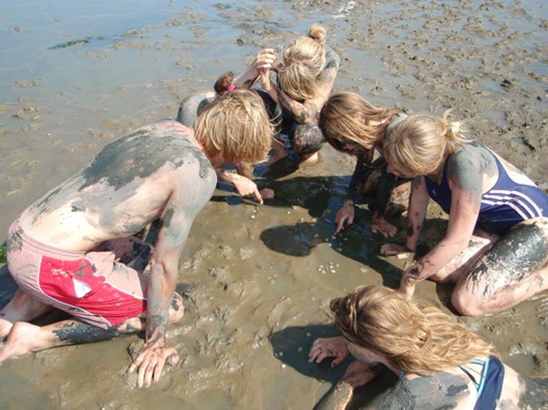 Teilnehmer malen im Feriencamp Hannover mit den Fingern im Watt
