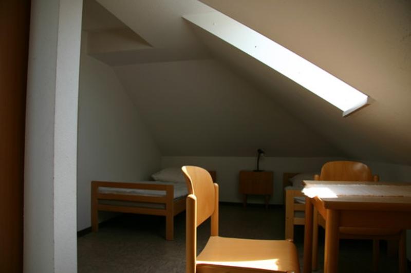 Ein Zimmer mit Bett, Tisch und Stuhl im Feriencamp Hannover