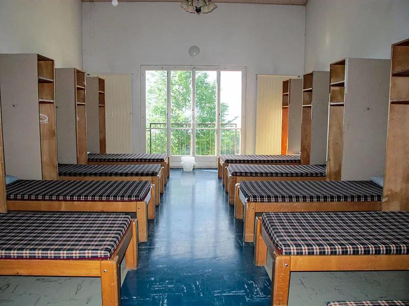 Schlafzimmer mit Betten und Schränken bei einem Feriencamp Schweiz