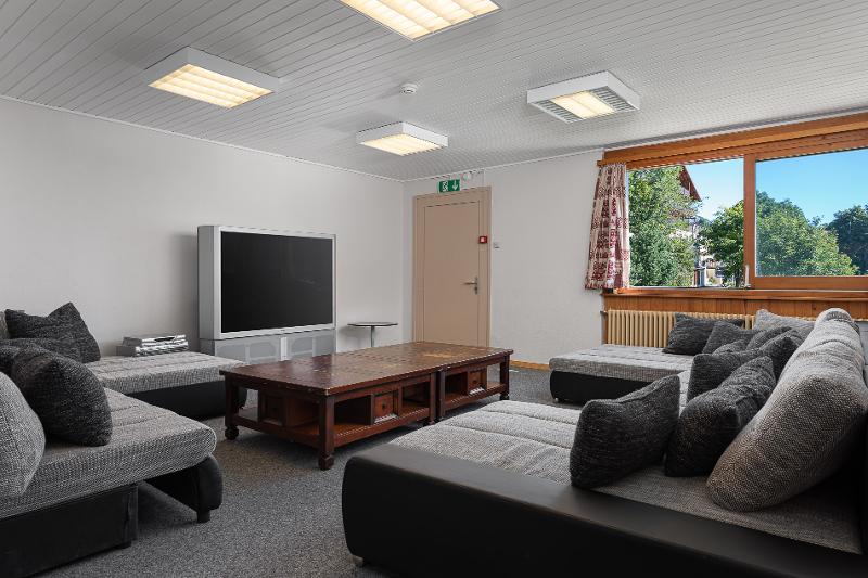 Sitzecke mit Couch, Tisch und Fernseher auf Sprachreise Schweiz