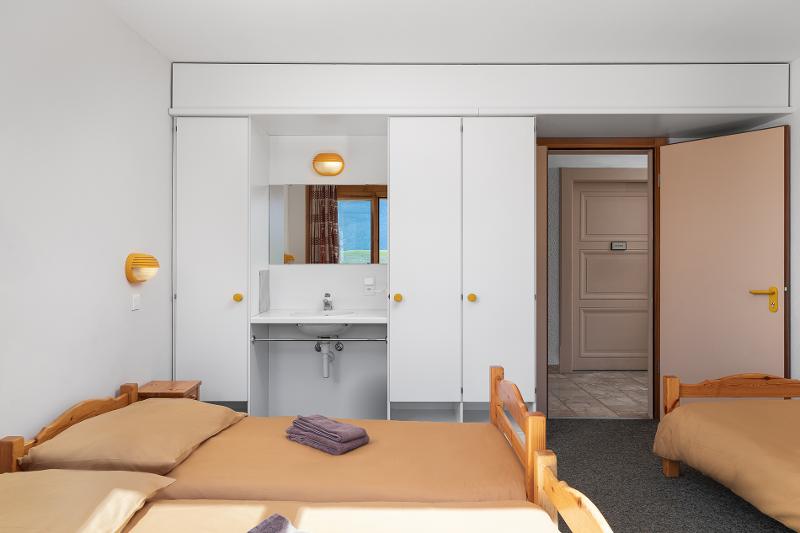Zwei Betten und ein Waschbecken in einem Zimmer auf Sprachreise Schweiz