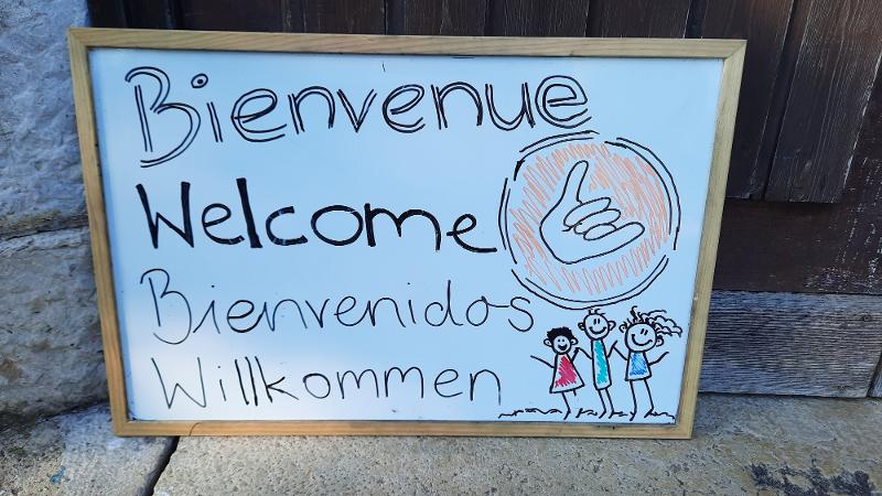 Ein Schild auf Sprachreise Schweiz auf dem Willkommen in verschiedenen Sprachen steht