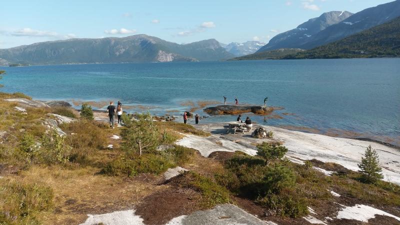 Die Teilnehmer der Jugendreise laufen am Wasser des Sees entlang