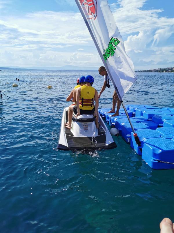 Drei Jugendliche im Teenscamp sitzen auf einem Jetski 