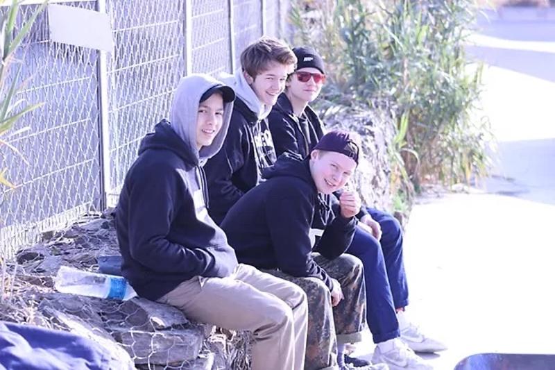 Jungs der Jugendreise Callela sitzen auf einer Mauer