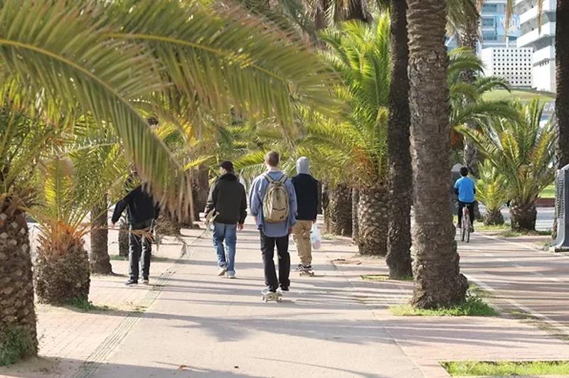 Eine Gruppe Jungs skatet bei einer Jugendreise Calella eine Straße entlang