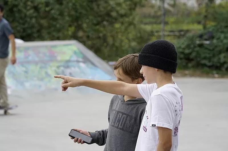 Zwei Jungen stehen in den Berlin Herbstferien nebeneinander und reden