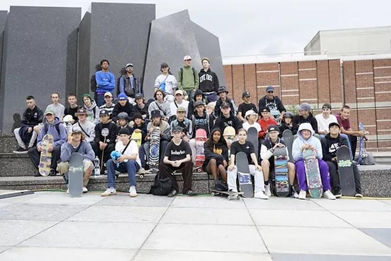 Kinder sitzen bei einem Gruppenfoto in den Berlin Herbstferien auf einer Treppe
