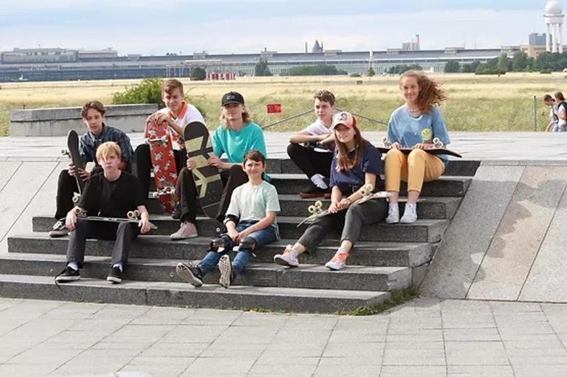 Kinder sitzen in ihren Berlin Herbstferien auf dem Tempelhofer Feld