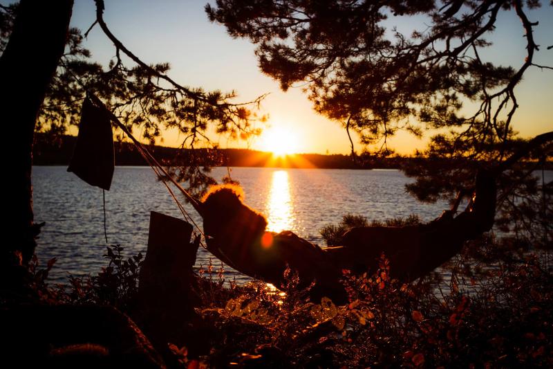 Direkt am See liegt jemand während der Ferienbetreuung in einer Hängematte