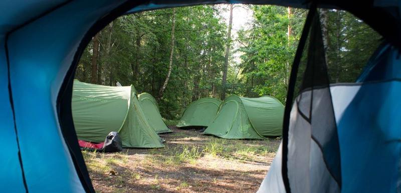 Der Blick aus einem Zelt heraus auf andere Zelte während der Ferienbetreuung Sommerferien