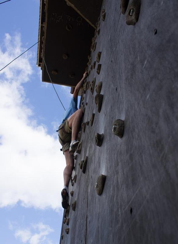 Ein Junge klettert während seiner Ferien-Betreuung an einer Kletterwand