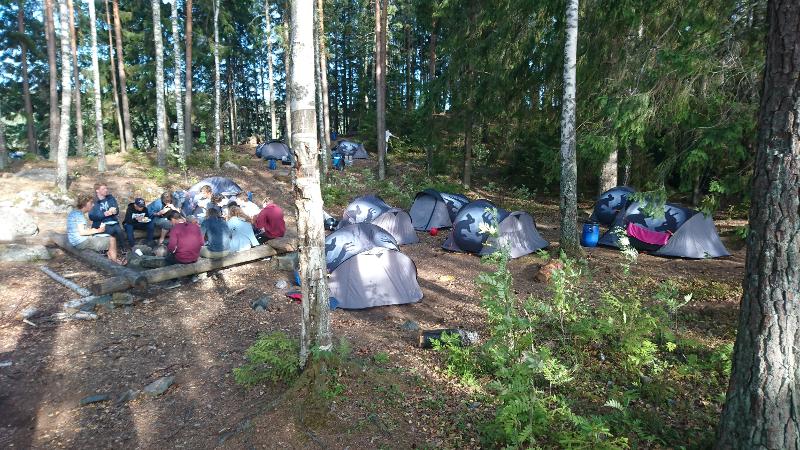 Die Teilnehmer der Ferienbetreuung sitzen gemeinsam in ihrem Camp zusammen