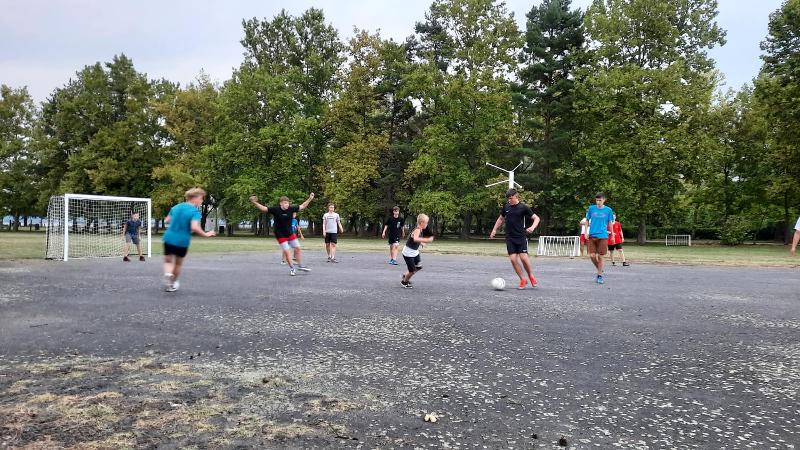 Eine Gruppe Kinder spielt Fußball auf einem Platz im Ferienlager Deetz.