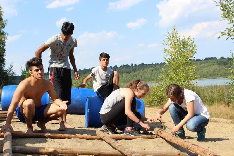 Die Kinder bauen im Outdoorcamp ein Floß