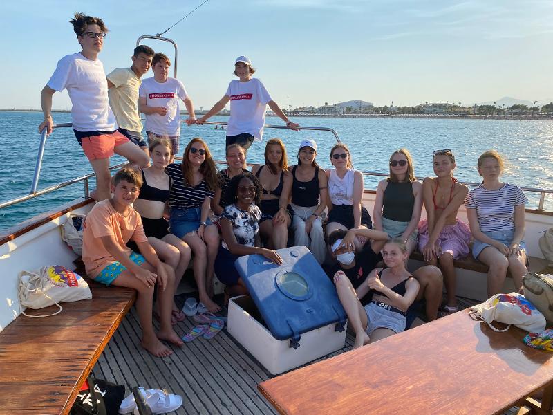 Teilnehmer der Jugendreise Sommerferien sitzen auf einem Boot