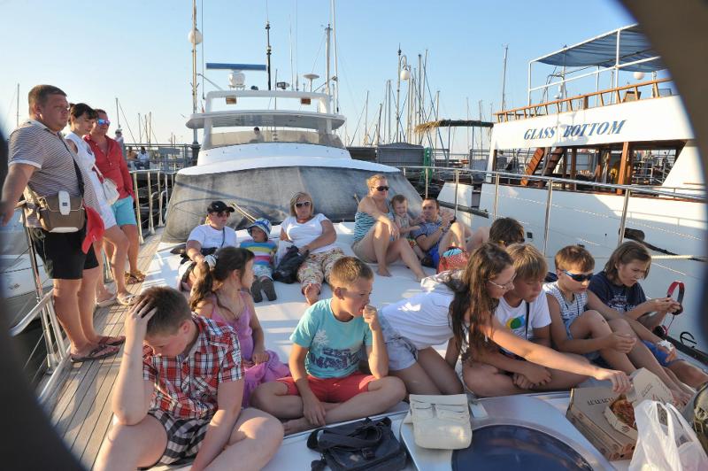 Eine Gruppe sitzt auf Jugendreise Sommerferien auf einem Boot