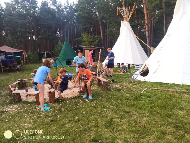 Die Gruppe chillt gemeinsam im Survivalcamp auf dem Campingplatz