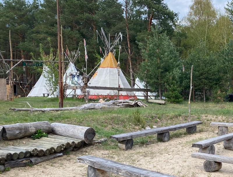Der Campingplatz im Survival Camp hat eine Sitzecke mit Bänken