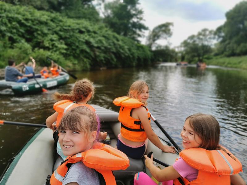 Kinder des Ferienprogramms in Sachsen fahren Schlauchboot