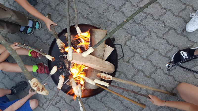Im Ferienprogramm in Sachsen essen Kids Stockbrot