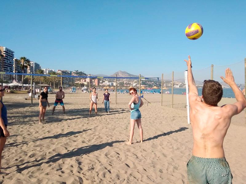 Die Jugendlichen liefern sich in ihrer Freizeit ein packendes Volleyball Spiel bei schönstem Wetter am Strand bei den Sprachreisen Spanien für Schüler Sommerferien