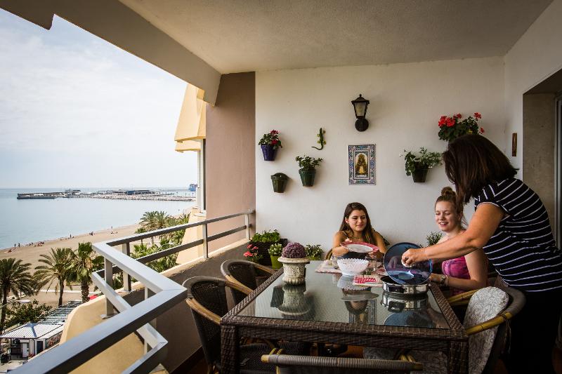 Zwei Mädchen sitzen aufm Balkon und essen mit ihrer Gastmutter bei den Sprachreisen Spanien mit Gastfamilie