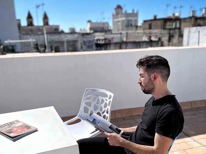 Ein Junge sitzt bei einer Jugendreise nach Spanien lesend auf einem Balkon
