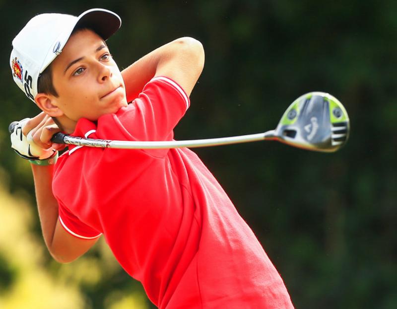  Participante rapaz a lançar uma bola de golf no campo de férias golf 