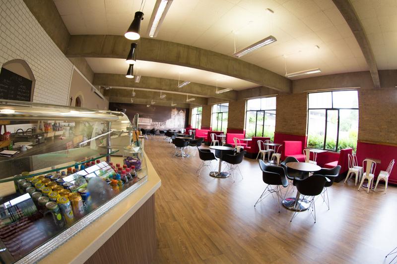 In der Lounge auf Sprachreise England stehen Tische und eine Snackbar