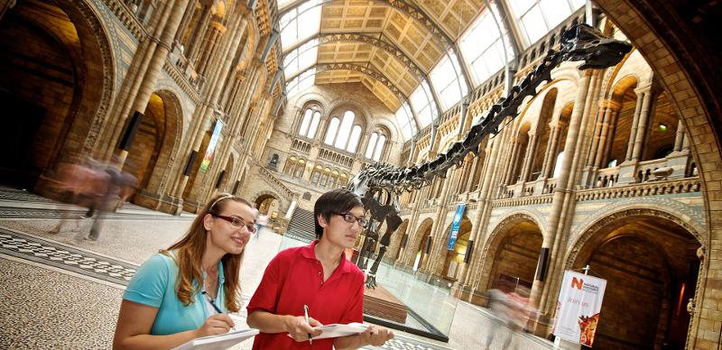 Zwei Schüler stehen auf Sprachreise nach England in einem Museum und schreiben etwas auf