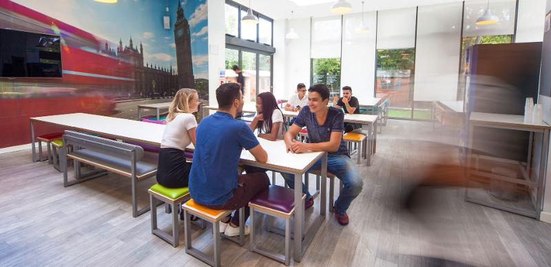 Studenten sitzen im Sprachcamp England an den Tischen der Cafeteria 