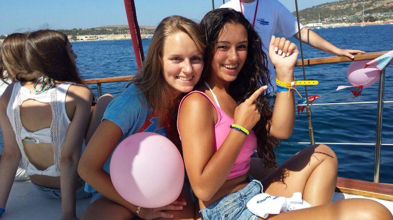 Zwei Freundinnen sitzen auf Schülersprachreise Malta auf einem Boot und haben einen Luftballon in der Hand