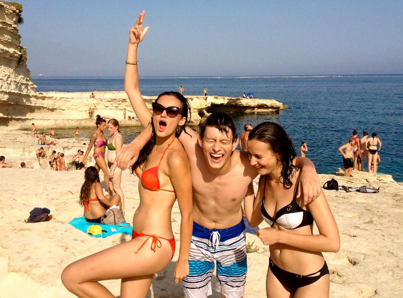 Auf Sprachreise Malta stehen einige Freunde am Strand an den Klippen