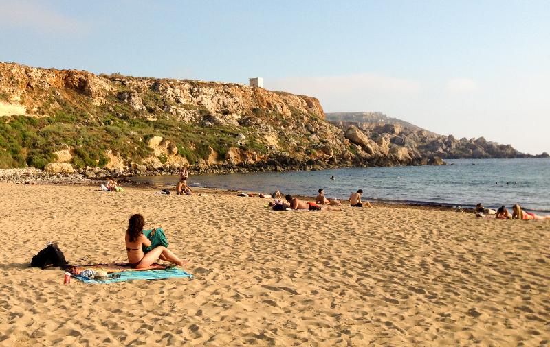 Am Strand liegen während der Sprachferien Malta ein paar Menschen